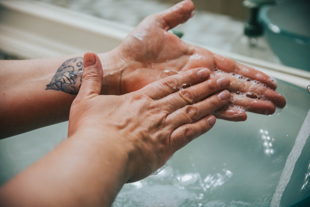 A person washing their hands carefully with soap and water